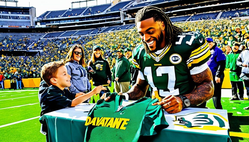 Davante Adams autographing a shirt for a young fan on the field